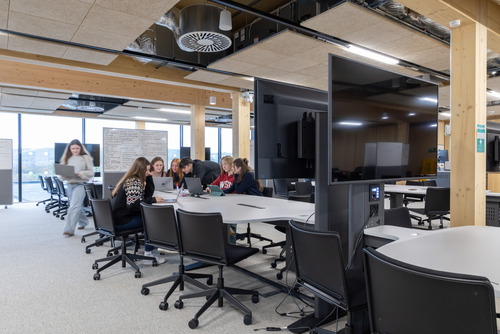 Students working together around tables in a modern, open-plan study space inside the University of Bristol’s Blagdon Building at Langford.